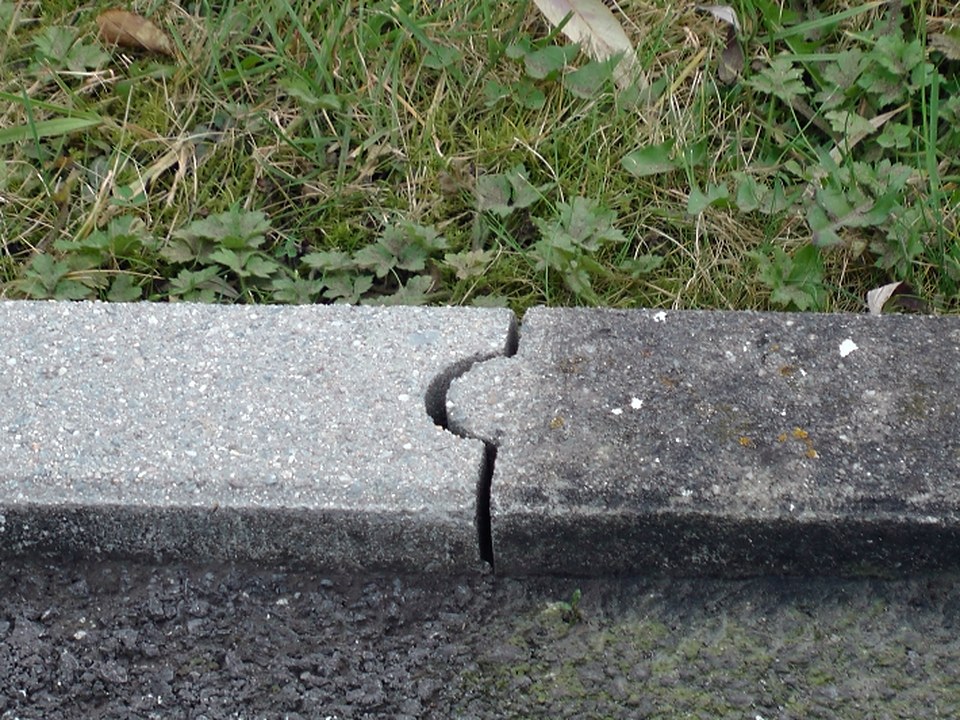 Gereinigter Bordstein aus Beton neben einem verschmutzten