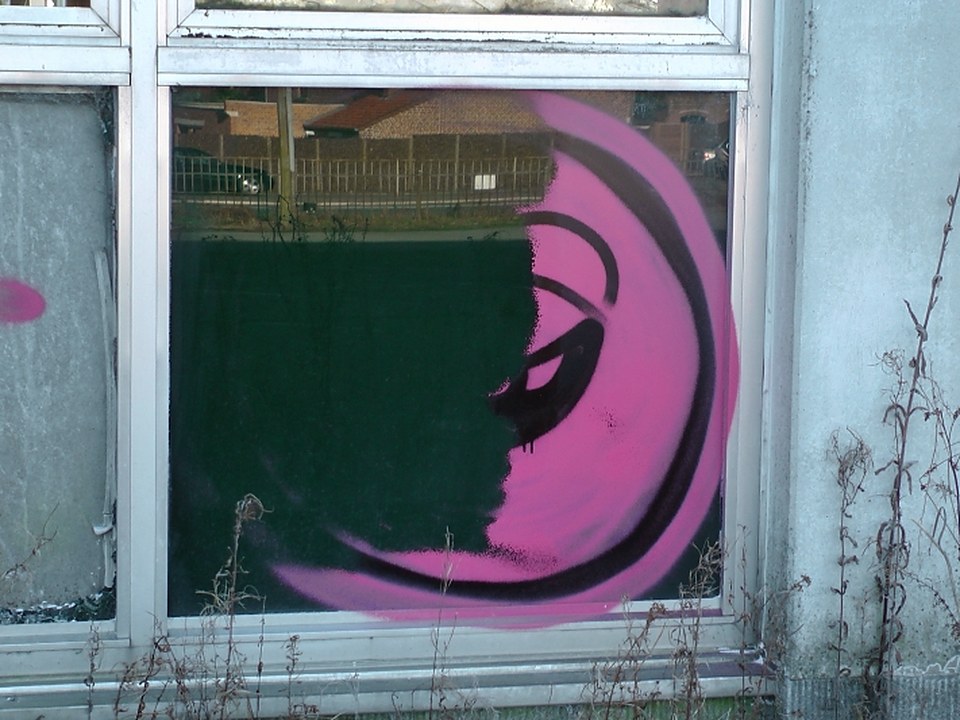 Eliminación de un grafiti en una ventana, a medias: el cristal de la izquierda ya está limpio