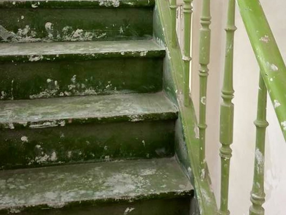 Holztreppe mit abblätternder grüner Farbe vor dem Niederdruckstrahlen