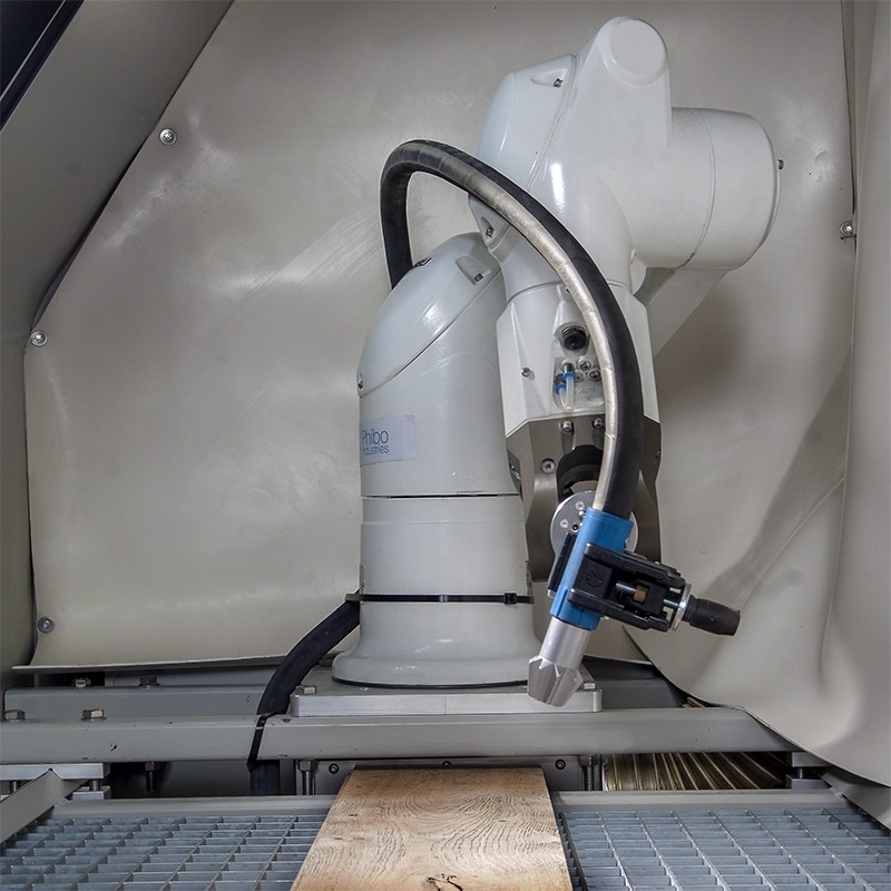 Robot arm with blasting nozzle inside a closed cell