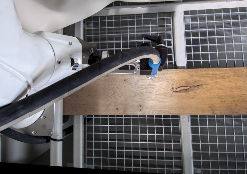 Robot arm treating a workpiece on the table