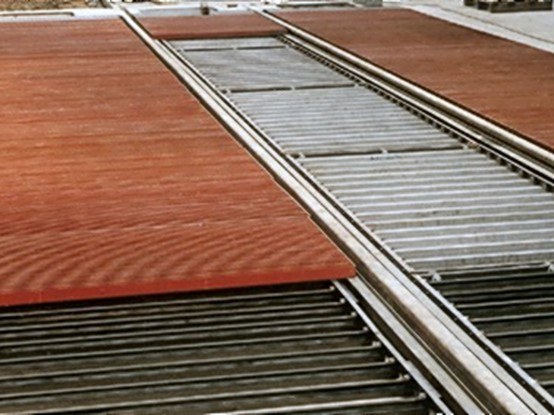 Scraper tracks with walkway gratings in the floor of a blast room
