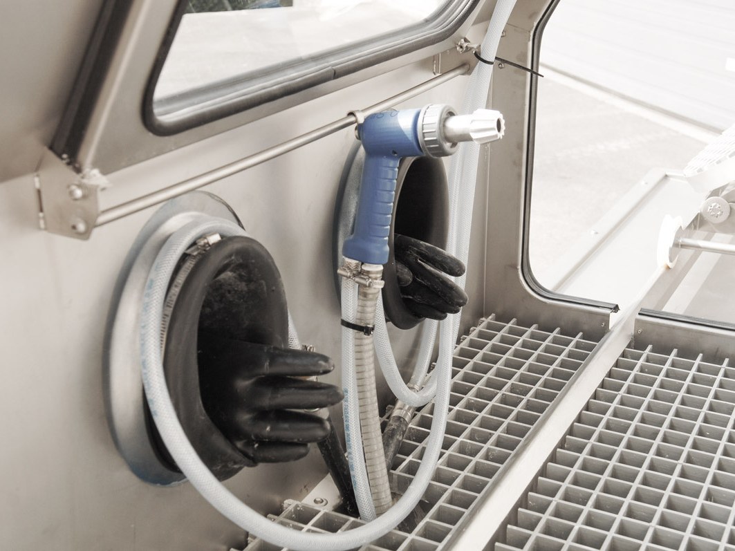 Gloves and process gun inside the Mistral cabinet, above the work grid