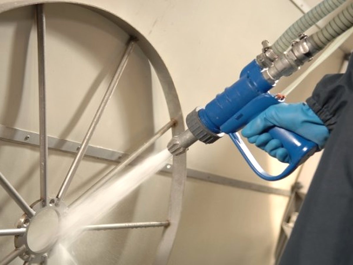 Operator treating a large stainless steel part with the process gun