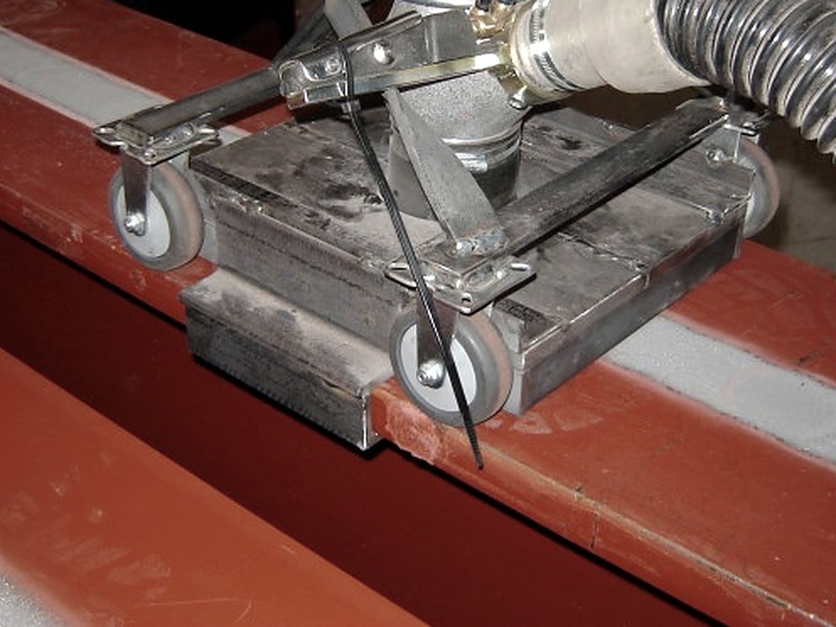 Blast head on wheels stripping a steel beam