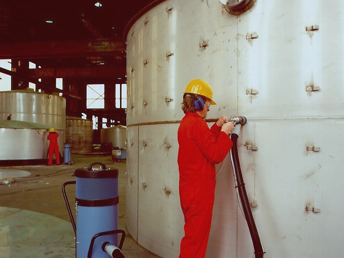 Operator treating the wall of a large tank