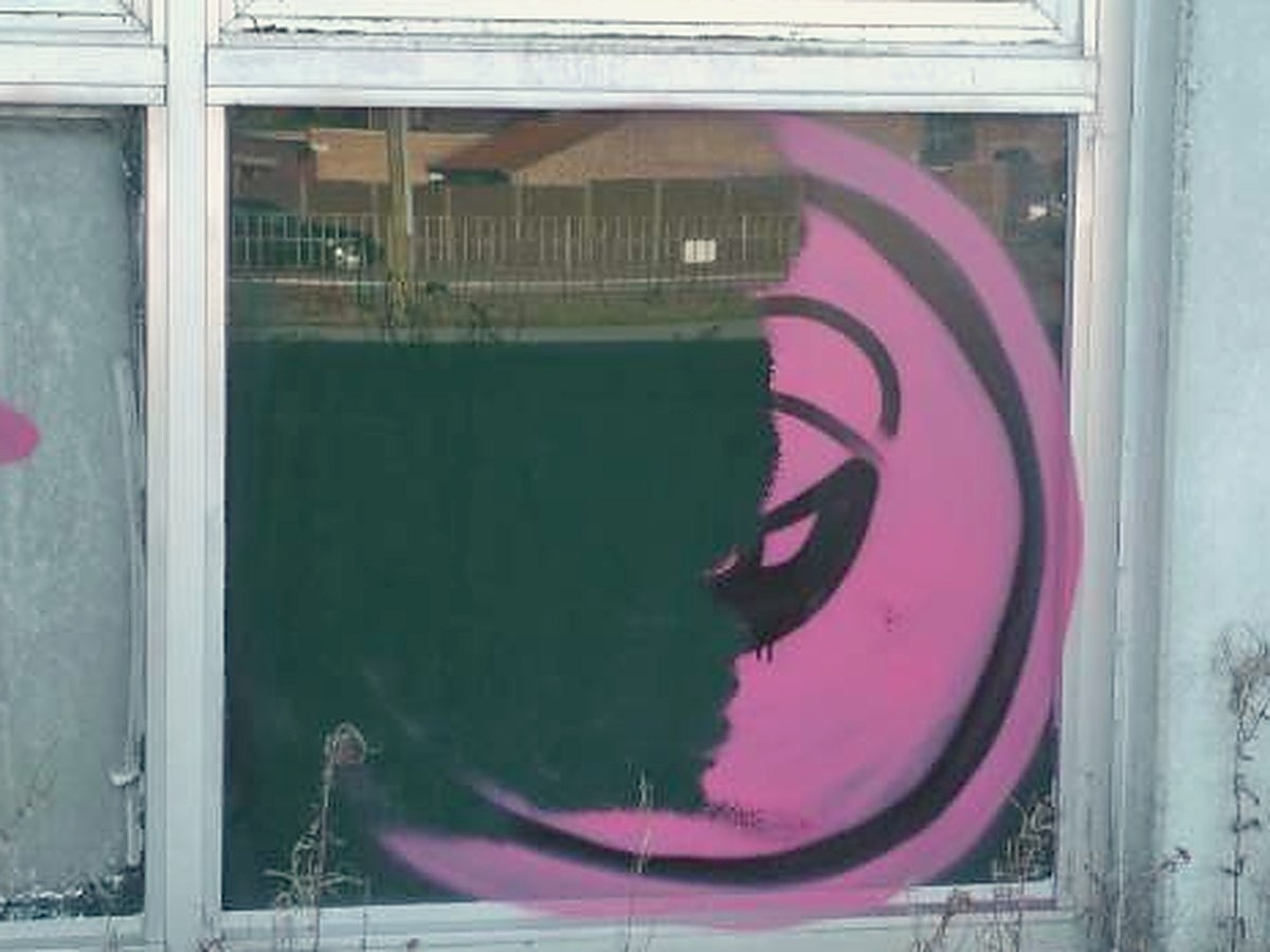 Luchtgommen op een raampartij, de graffiti links al weg en rechts nog intact