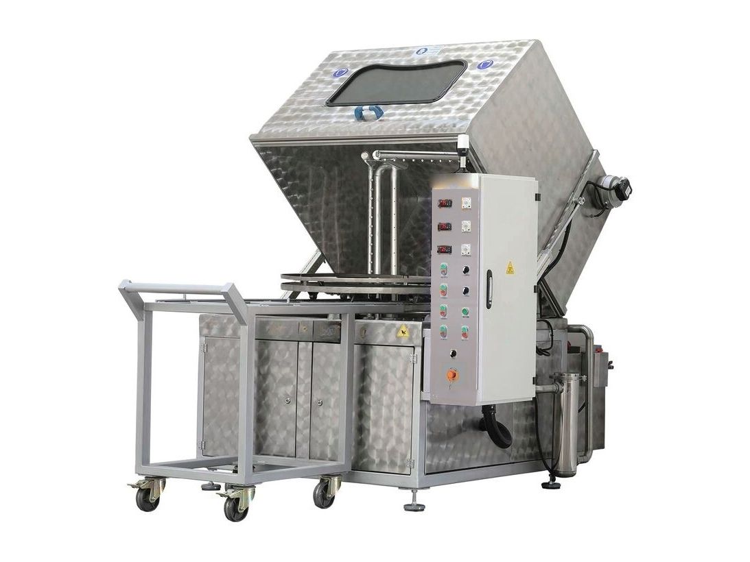 Machine de lavage multiprocédés avec capot basculé, panier rotatif, armoire de commande et chariot de chargement à côté